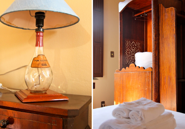 detalhes do quarto: o abajur com uma das garrafas clássicas de vinícola e o confessionário dentro do quarto